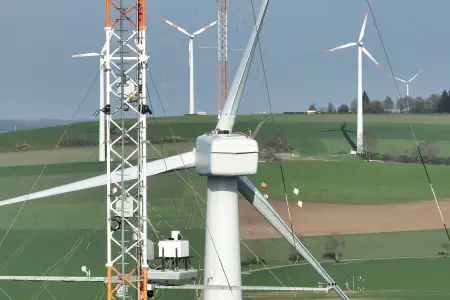 Nahaufnahme der nördlichen Forschungswindenergieanlage mit den meteorologischen Masten im Vordergrund und Hintergrund