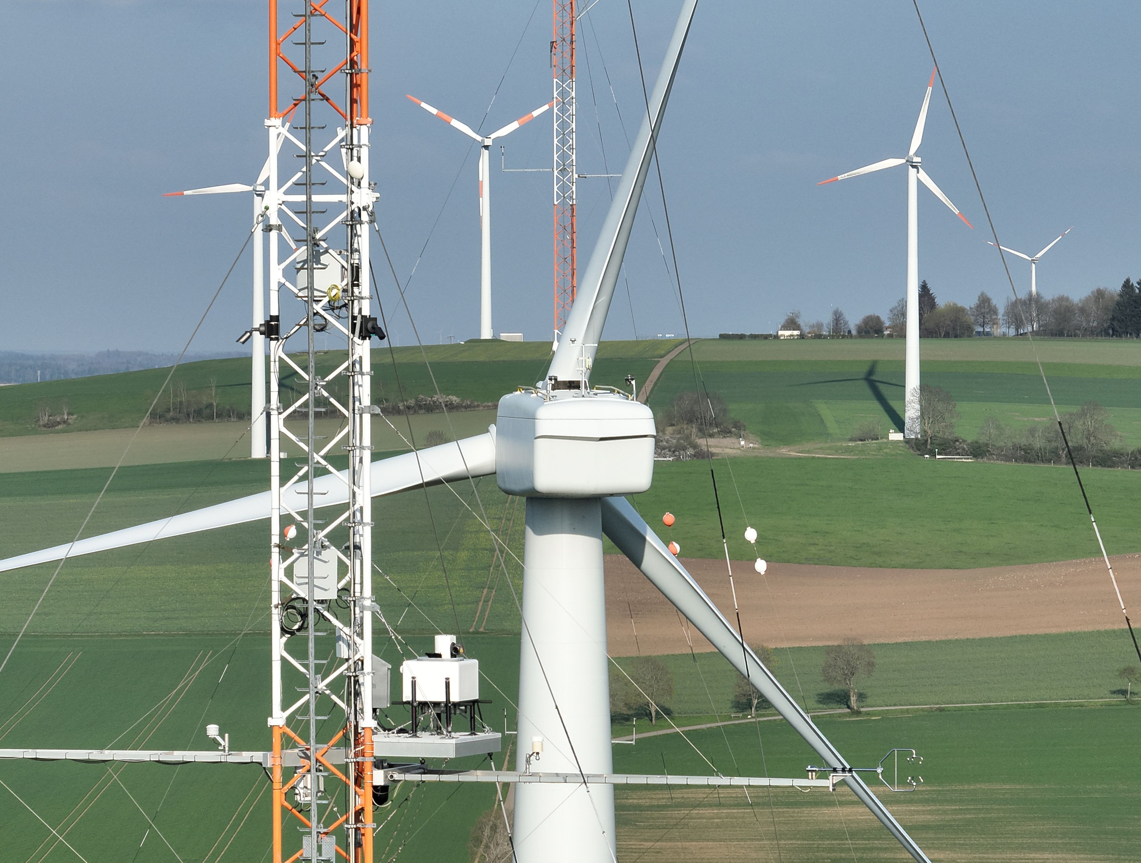 Close-up of the northern research wind turbine with the meteorological masts in the foreground and background
